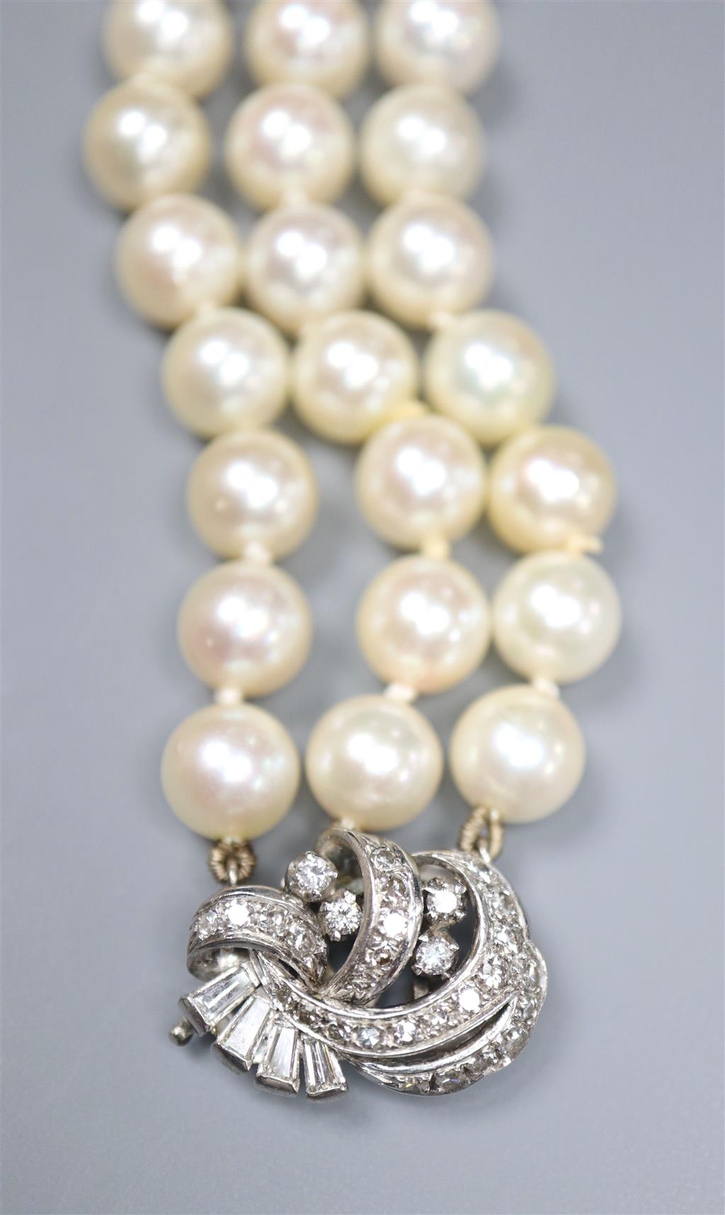 A triple strand cultured pearl bracelet, with diamond set white metal clasp, 17.5cm, gross 38.7 grams,